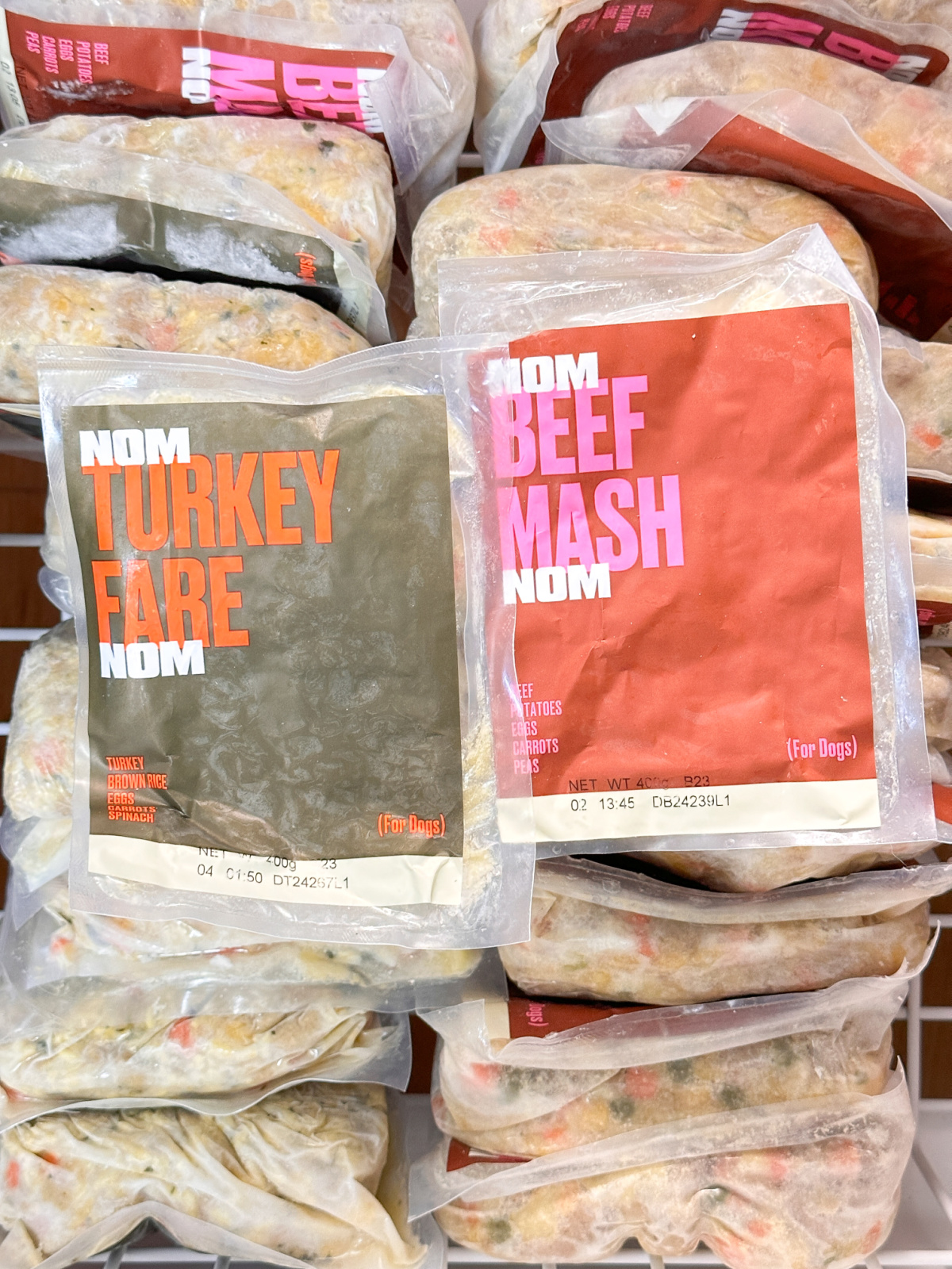 Image of Nom Nom dog food packets in freezer.