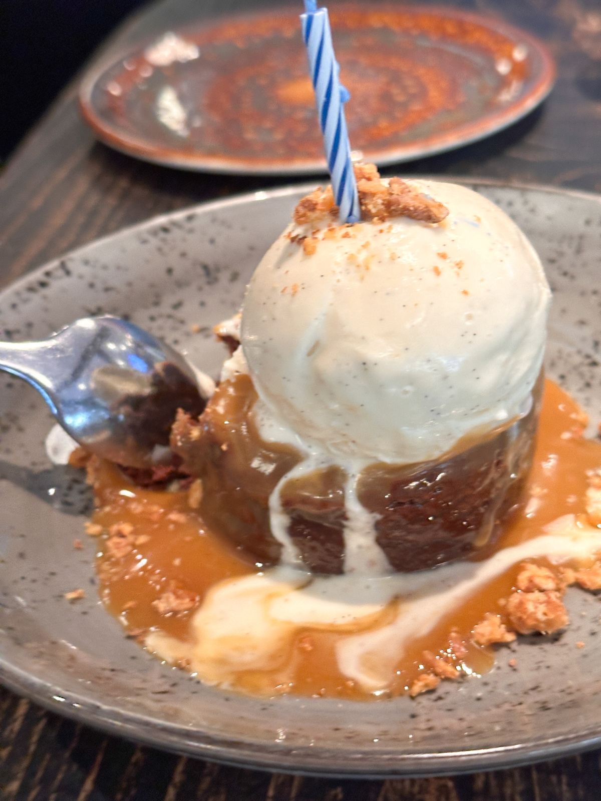 Birthday brownie topped with ice cream and candle.