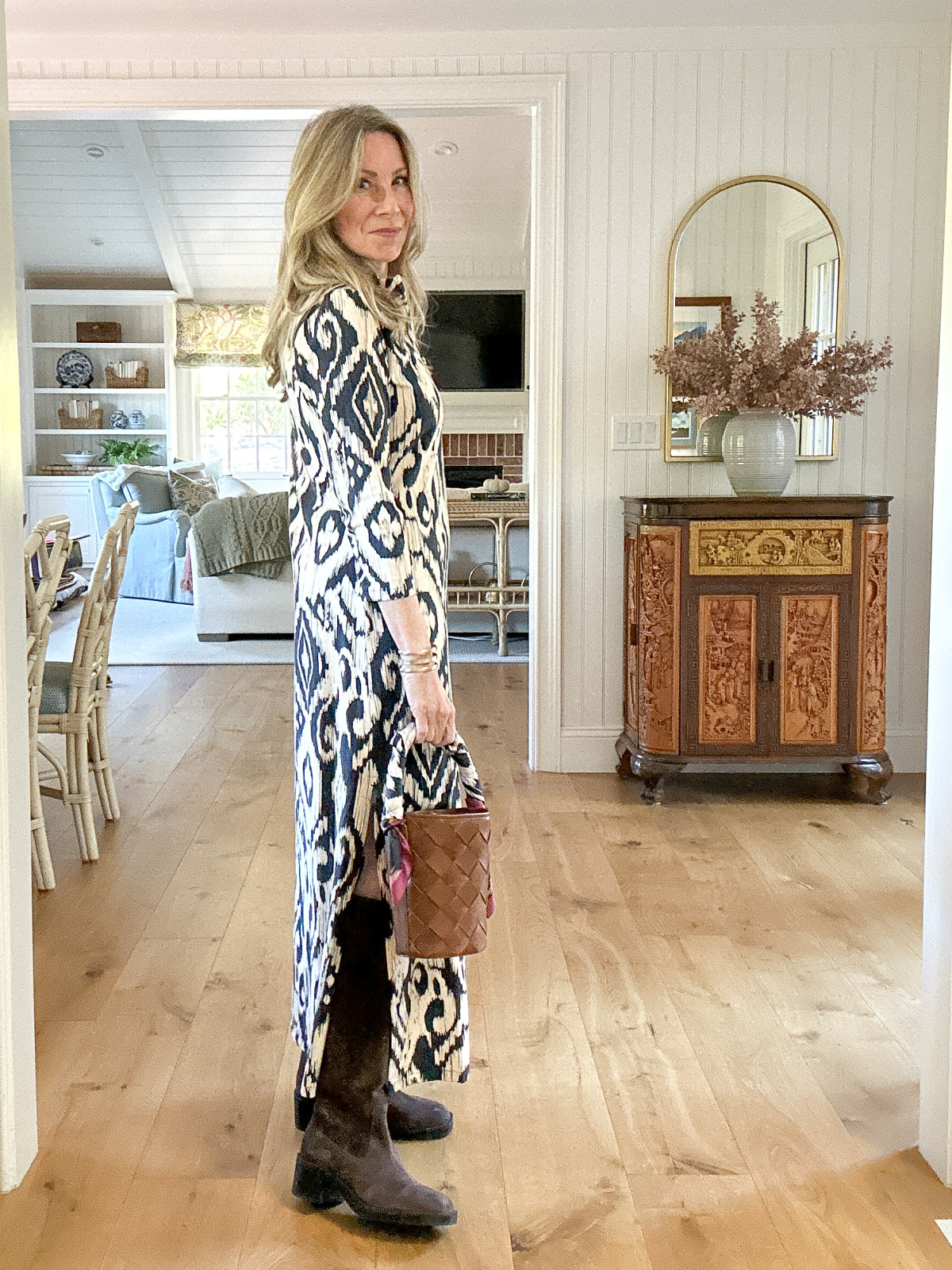 Woman wearing blue Ikat print dress and brown boots.