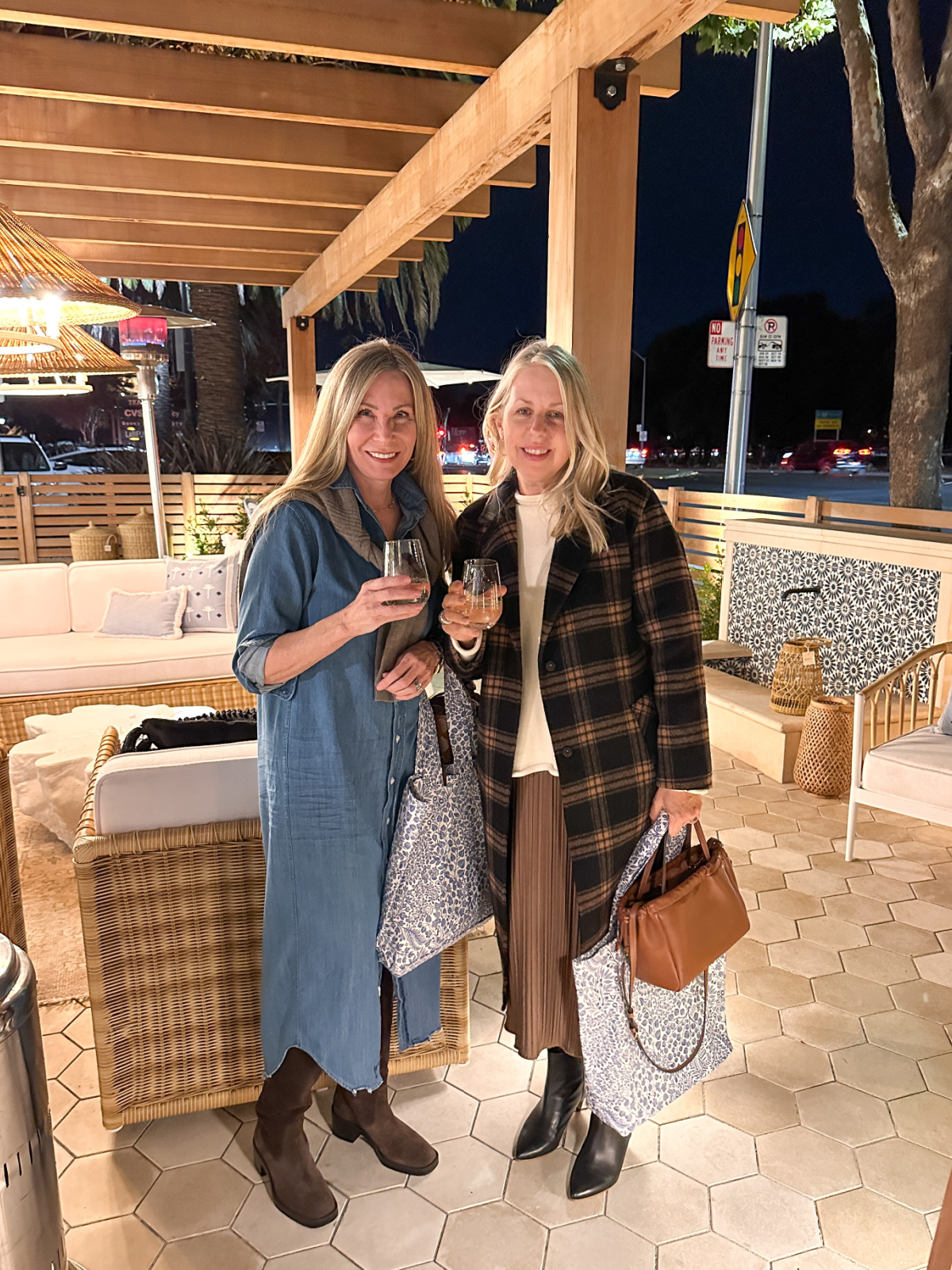 Two women holding wine glasses on patio of Serena & Lily store in Palo Alto.
