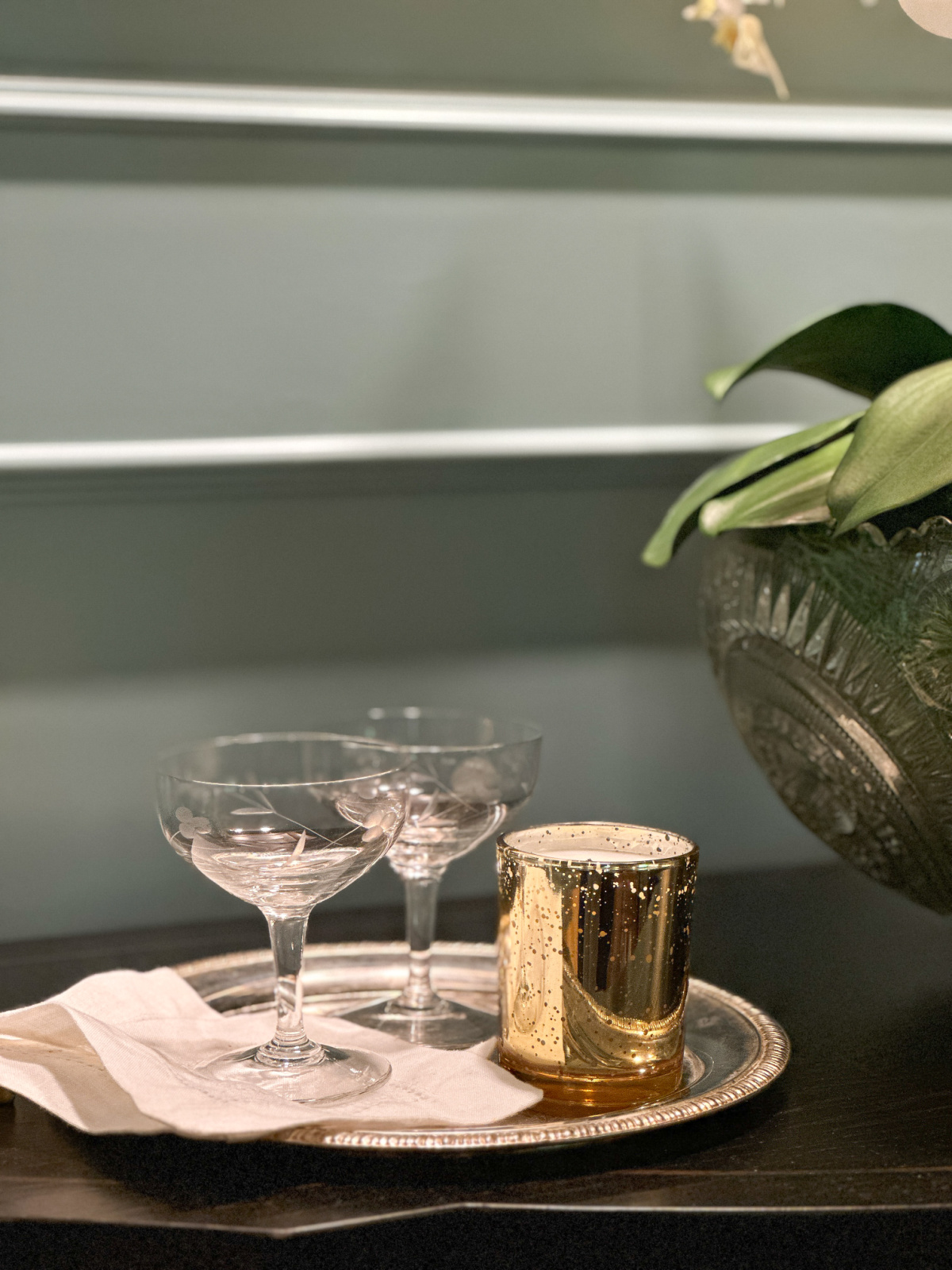 Silver tray with two champagne coups and a gold candle from Hood Canal Candle Co.