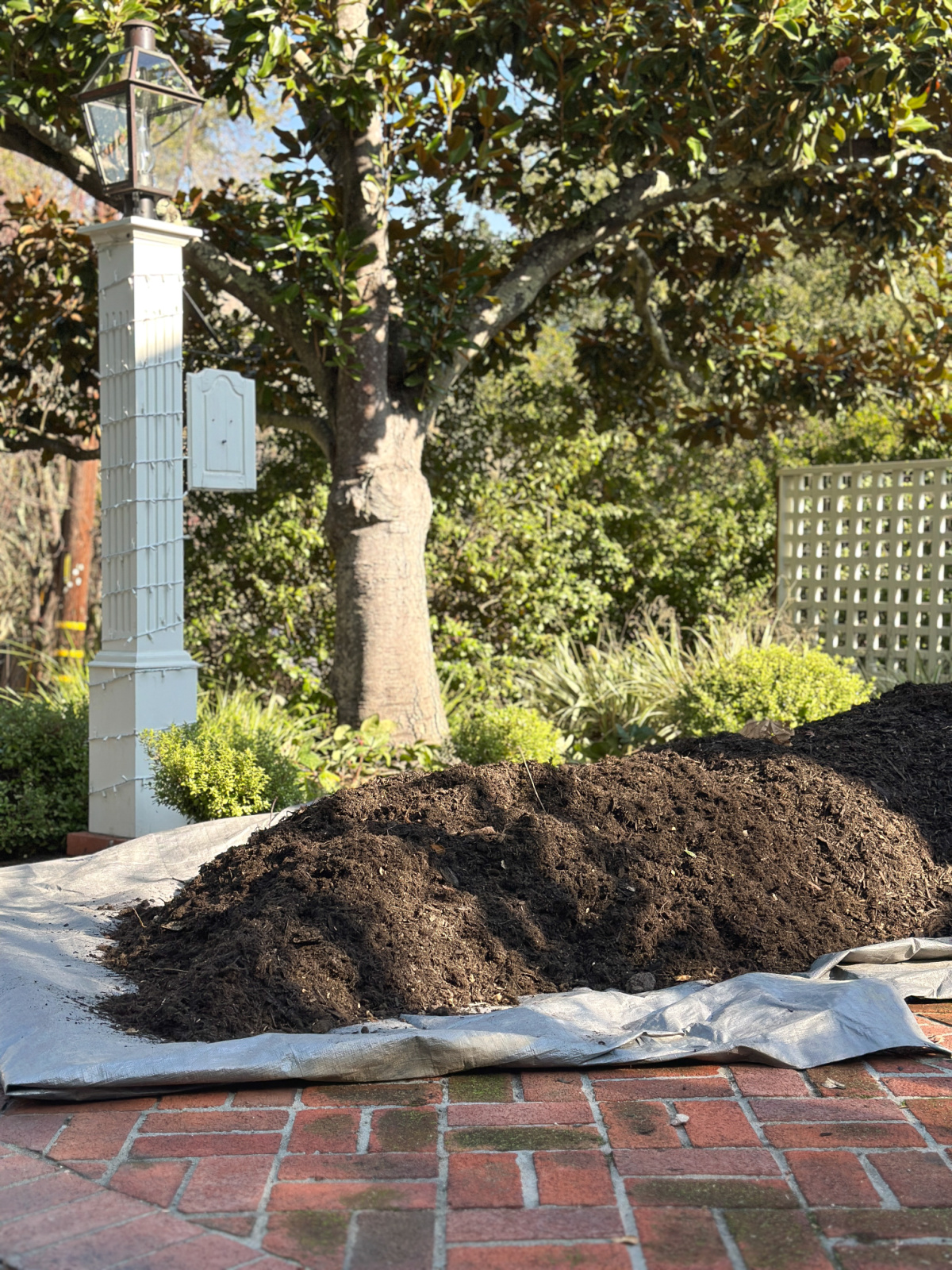 Pile of mulch on brick driveway.