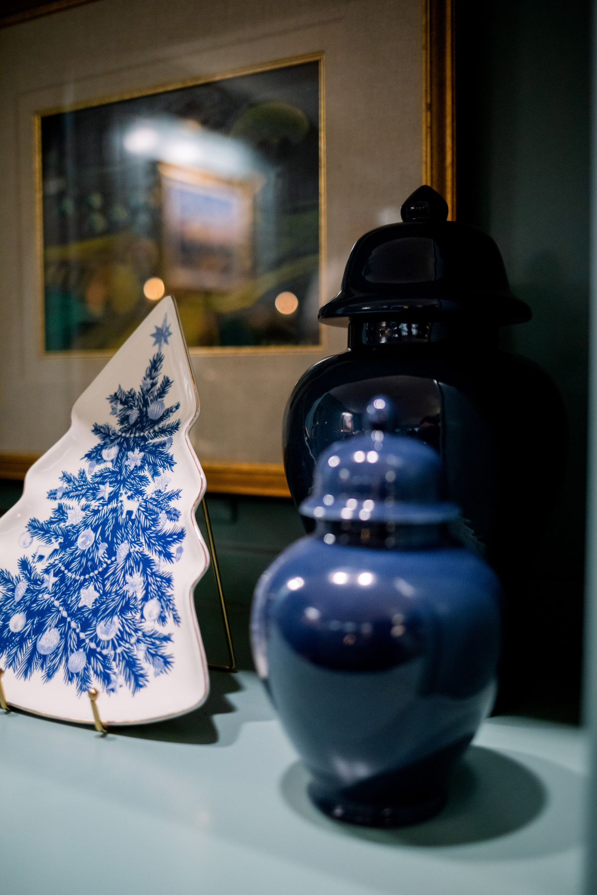 Blue and white Christmas tree shaped plate on an easel.