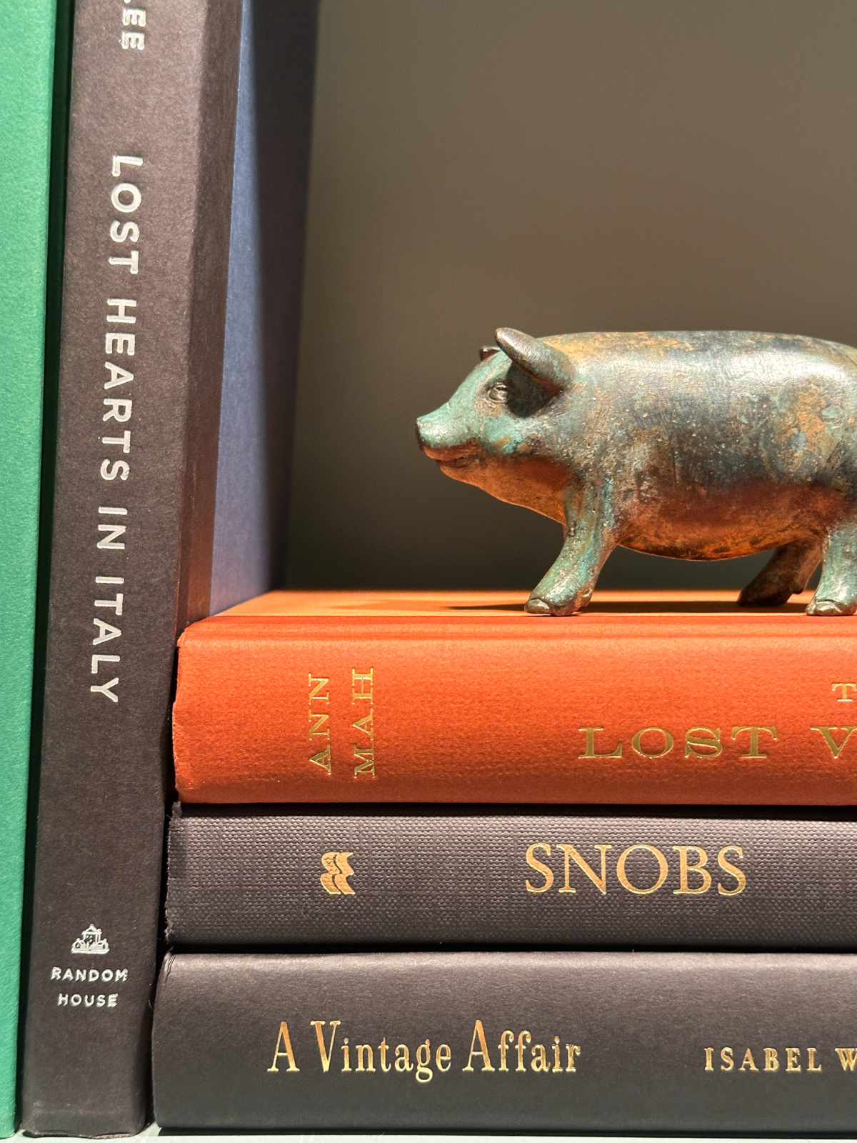 Book shelf with pig paperweight.