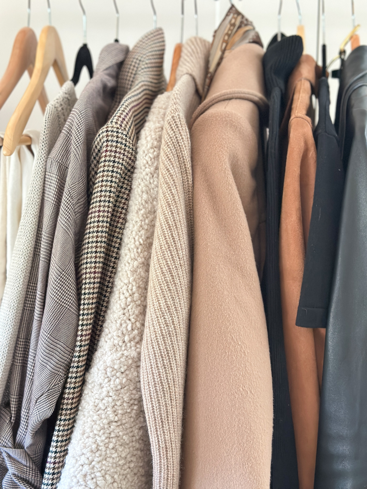 Neutral clothes hanging on rolling rack.