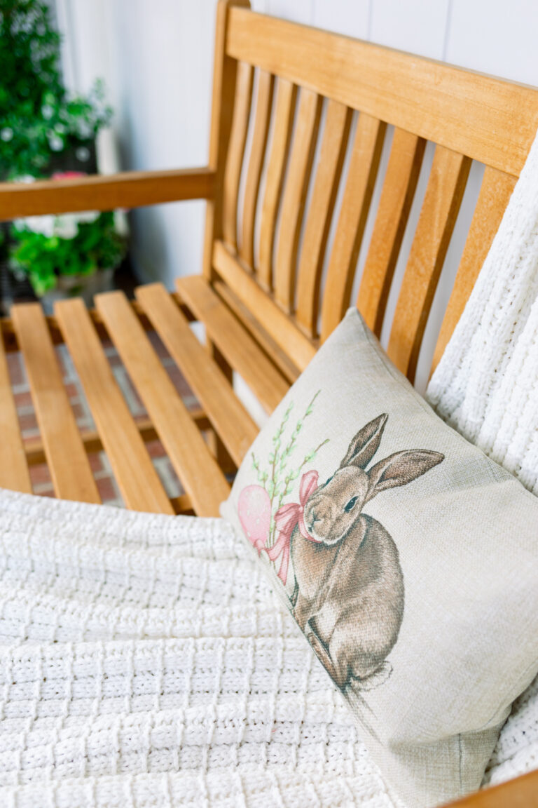 Bunny pillow on teak porch bench.