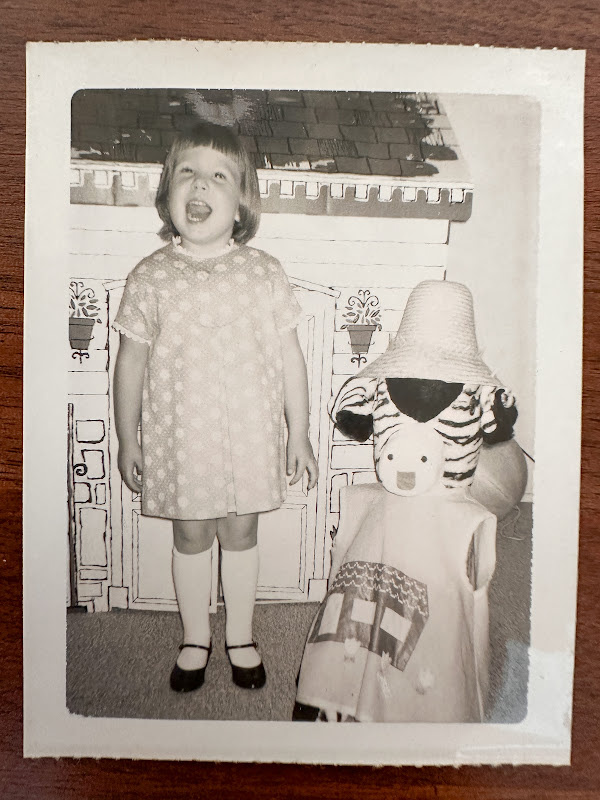 Little girl with stuffed zebra.