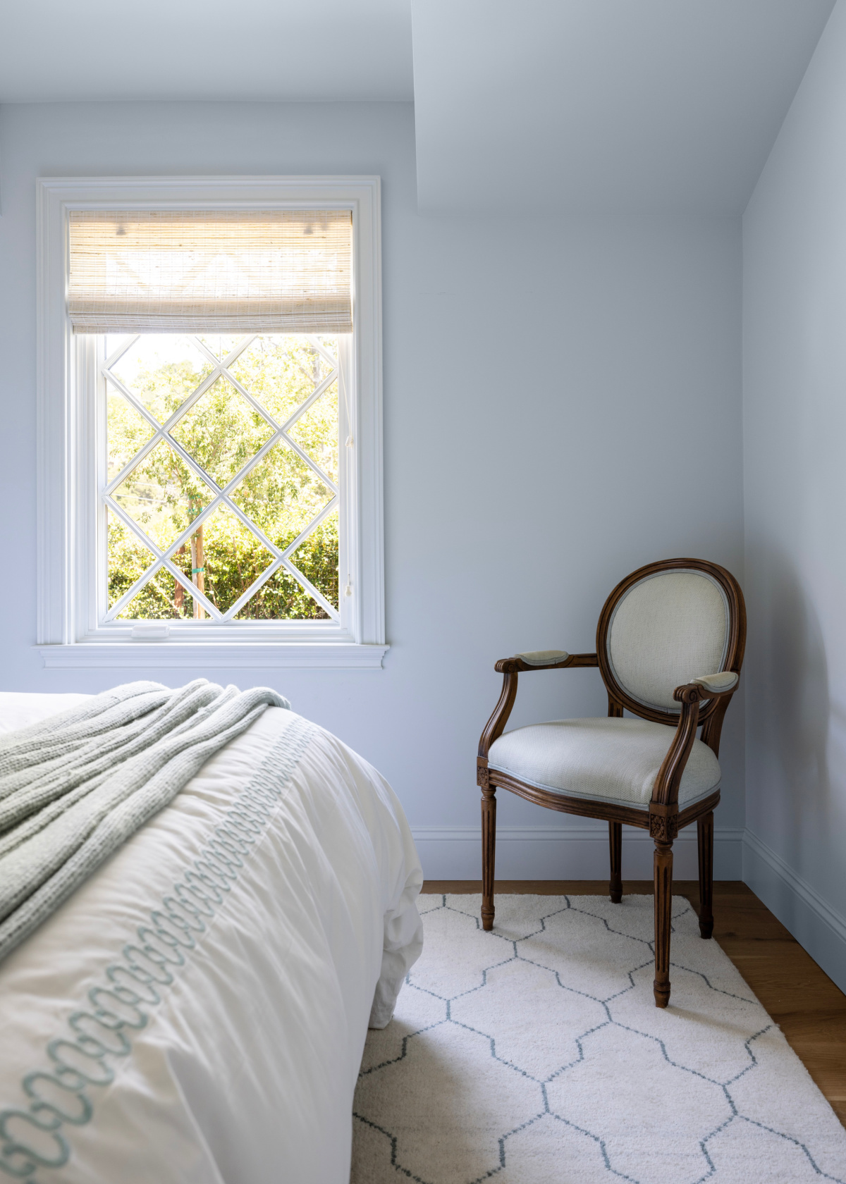 Blue bedroom with diamond pane window.