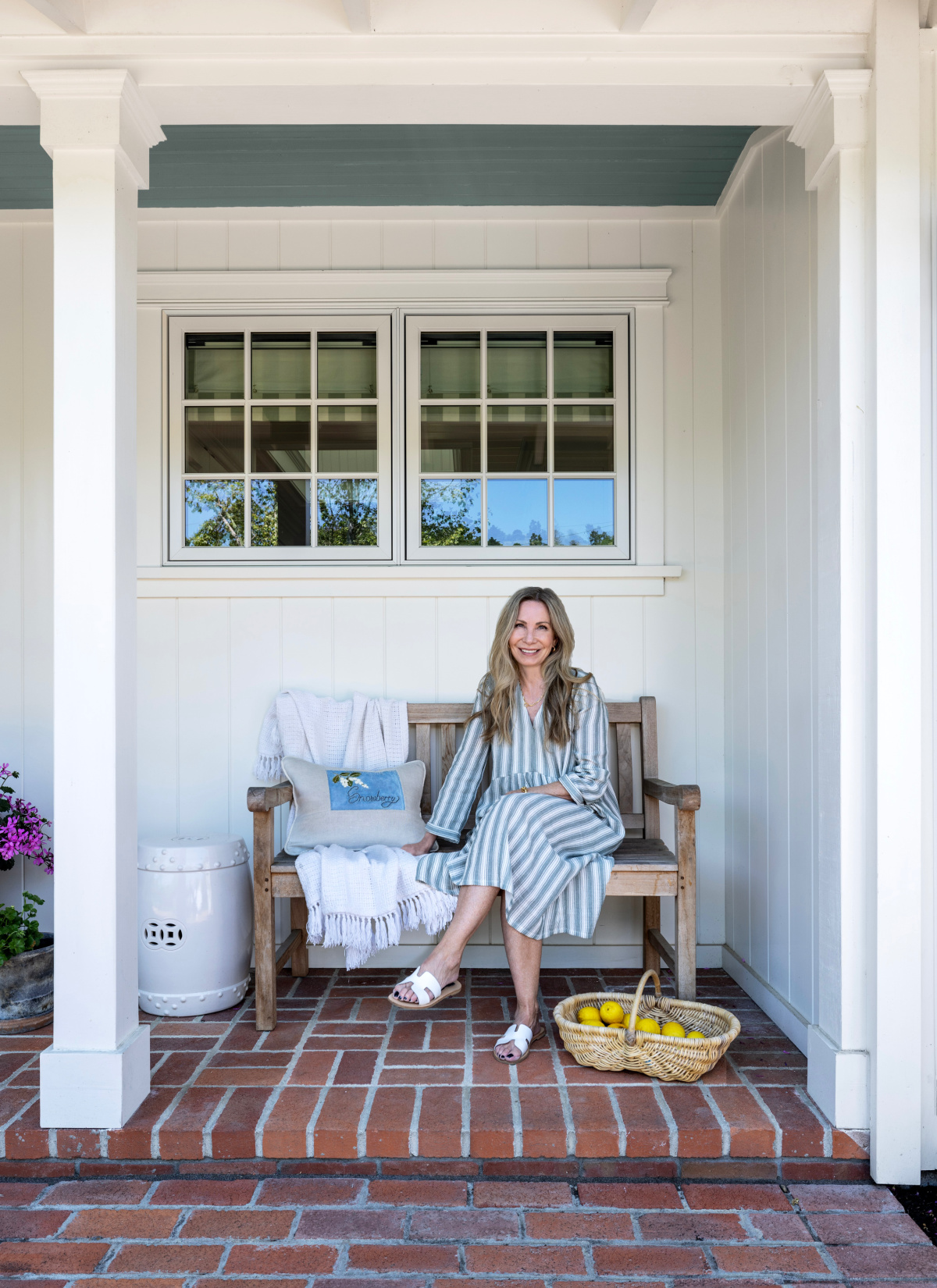Woman sitting on front porch bench.