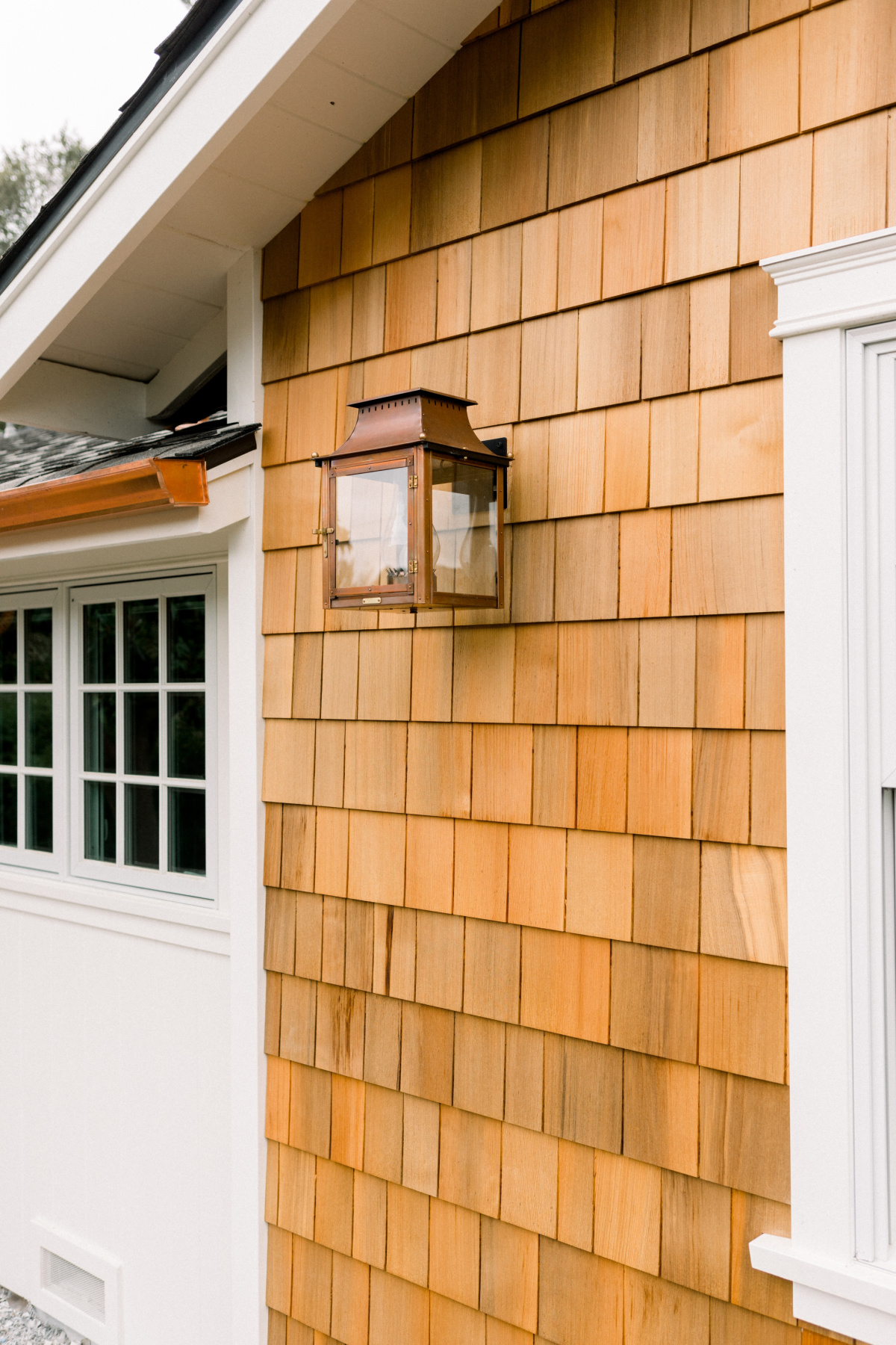 Exterior of shingled house with copper accents.