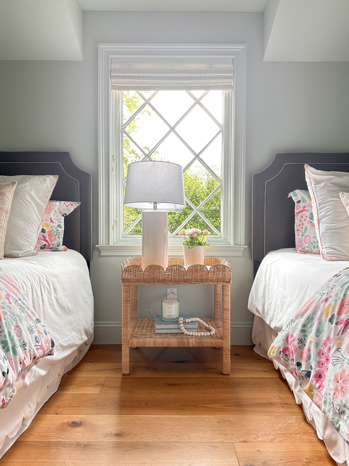Adorable girls bedrooms with twin beds and diamond pane window in between.