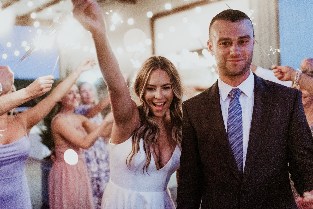 Bride and groom walking through sparklers at their wedding reception.