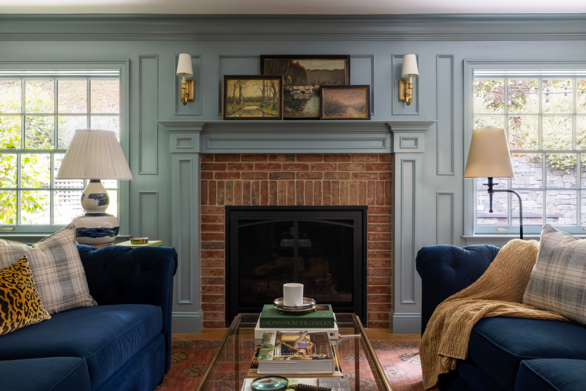 Fireplace flanked by blue velvet sofas.