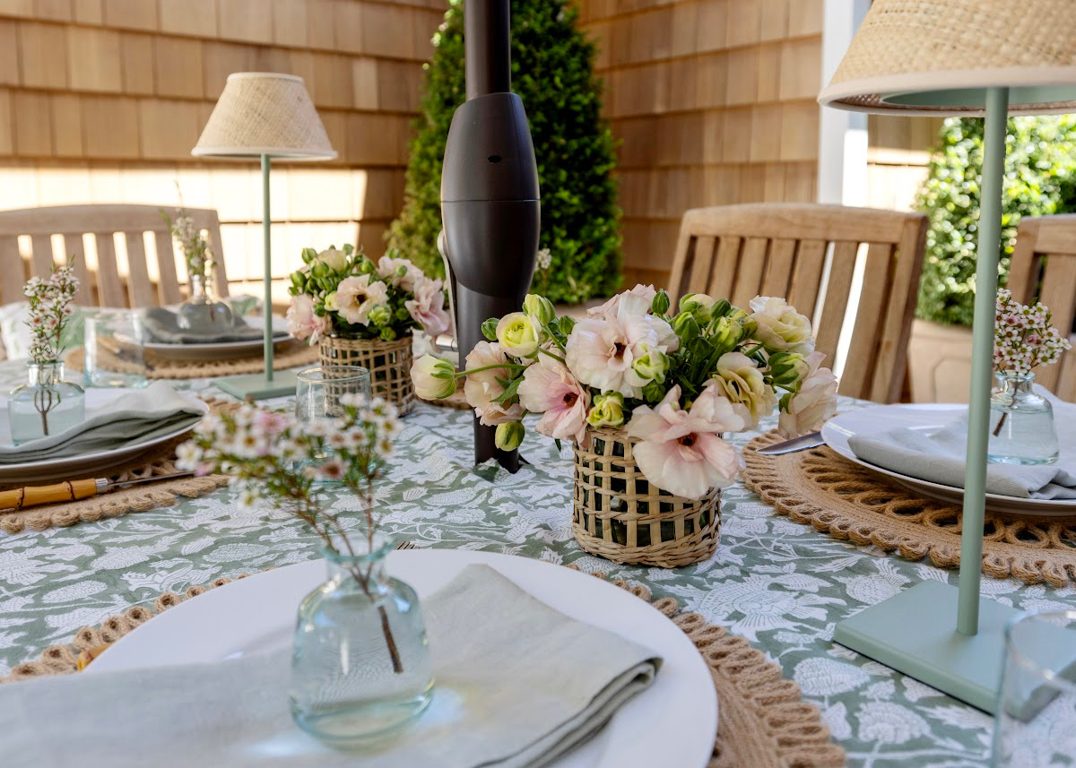 Outdoor summer table setting in green and white with peach flowers.
