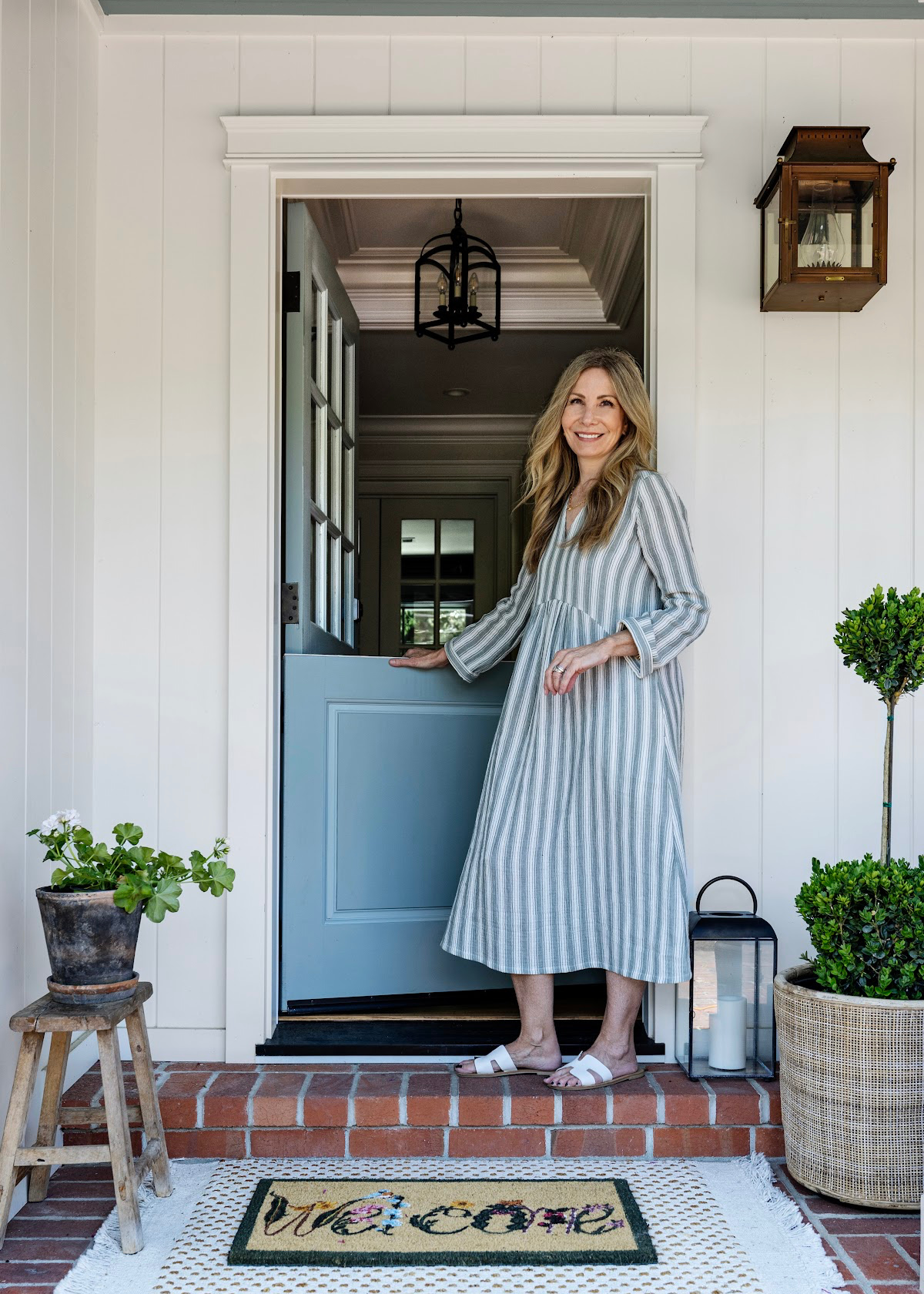 woman standing in front of blue dutch door.