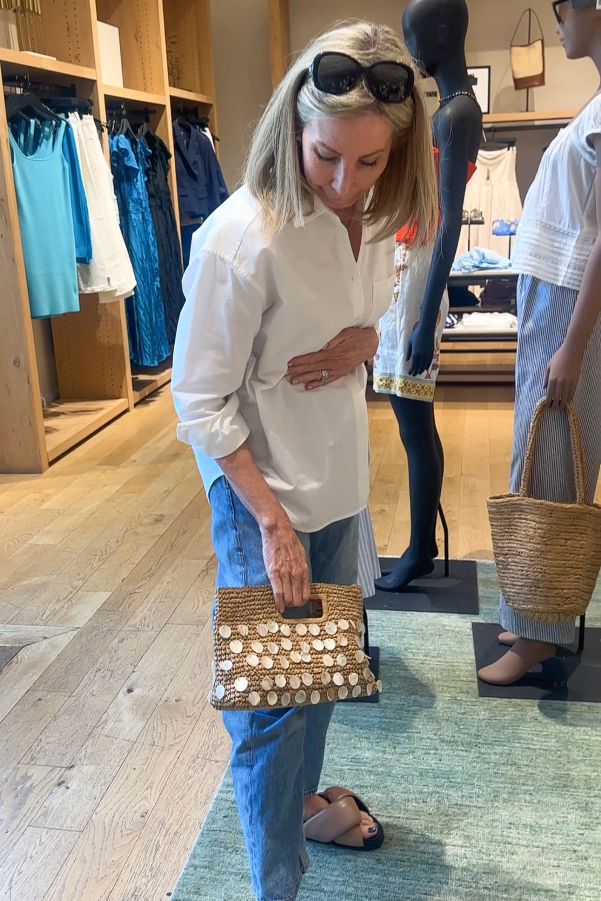 Woman in J.Crew store holding embellished tote.
