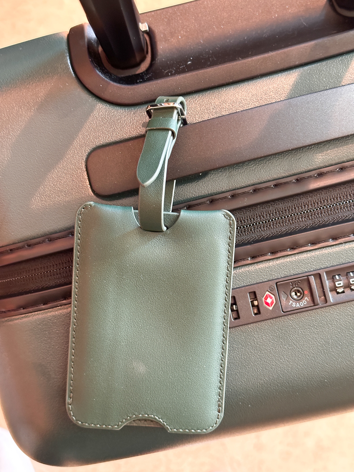 Quince expandable carry-on suitcase and luggage tag.