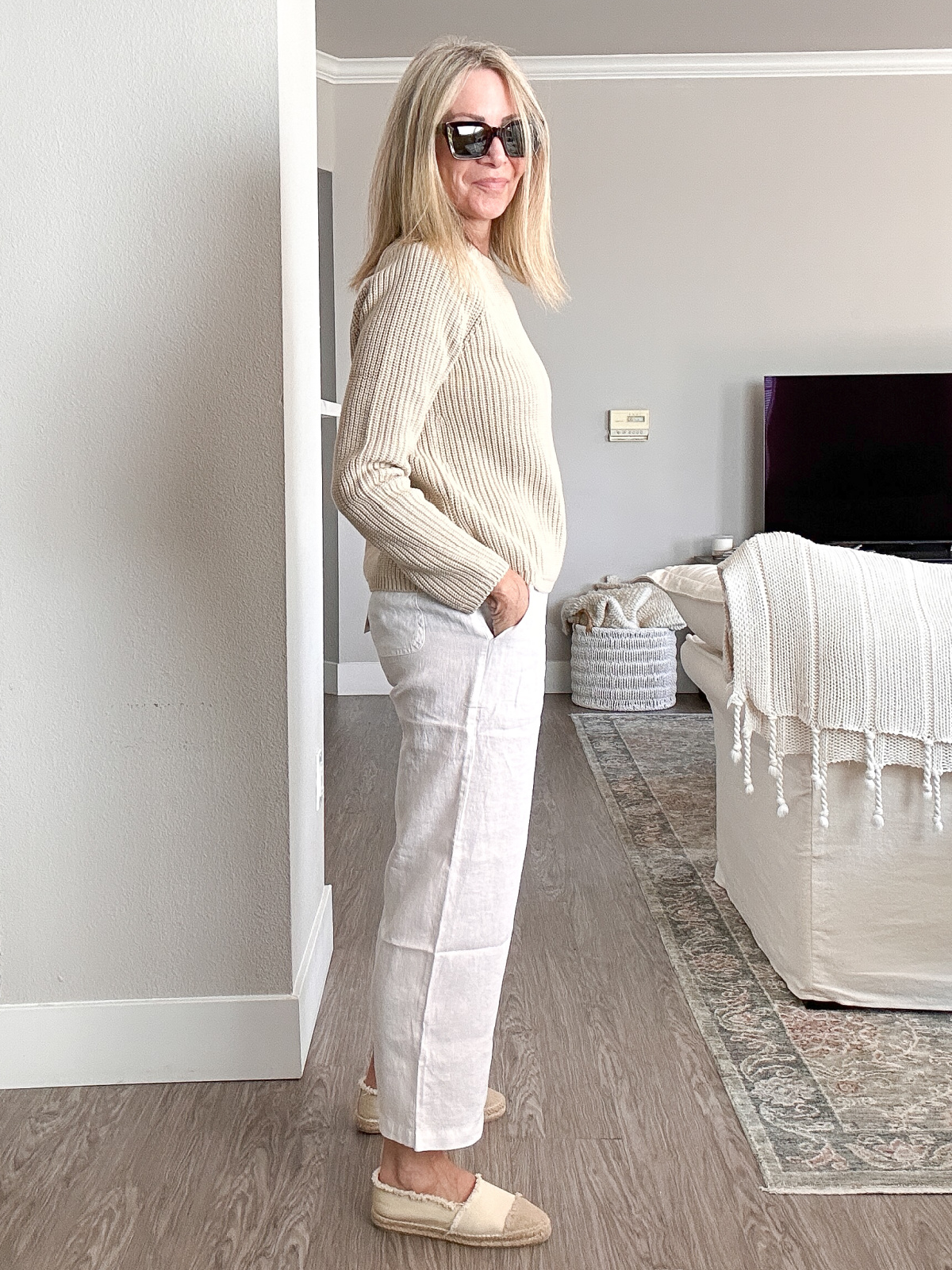 Woman wearing Quince fisherman sweater and linen pants.