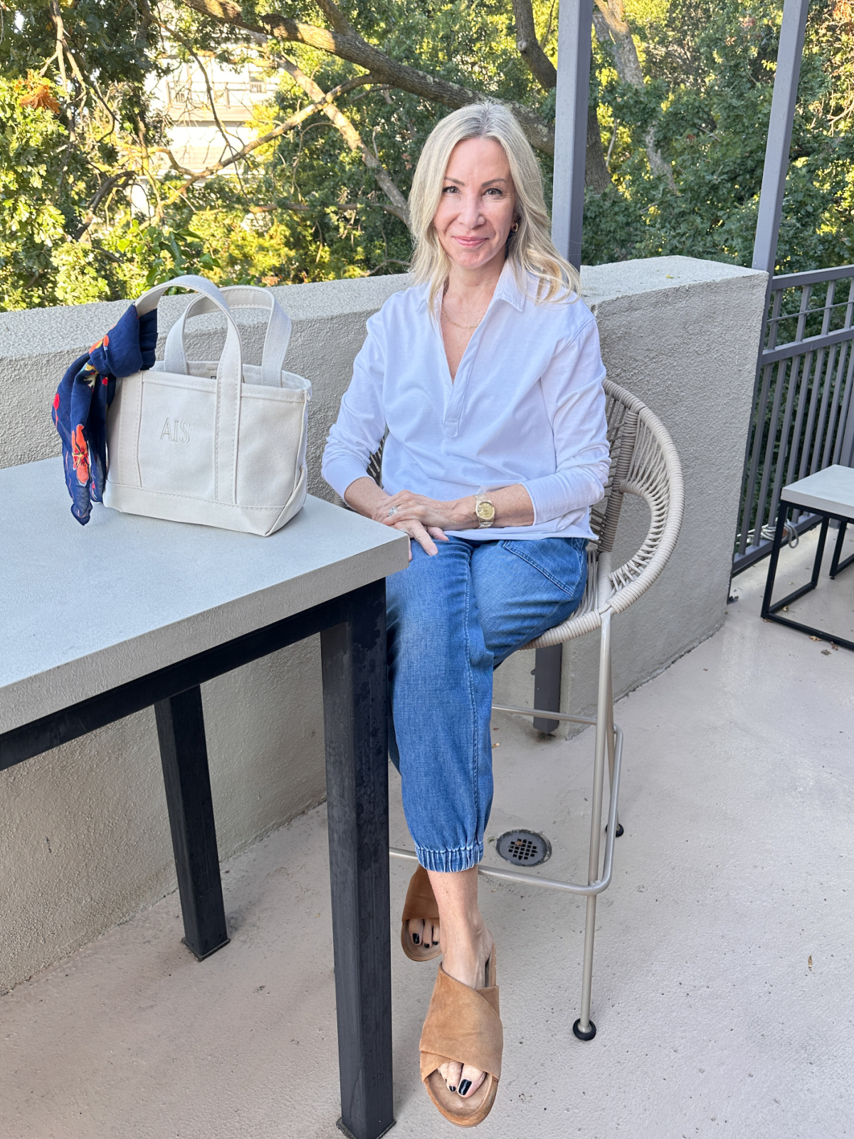 Woman sitting at outdoor table wearing outfit by Frank & Eileen.