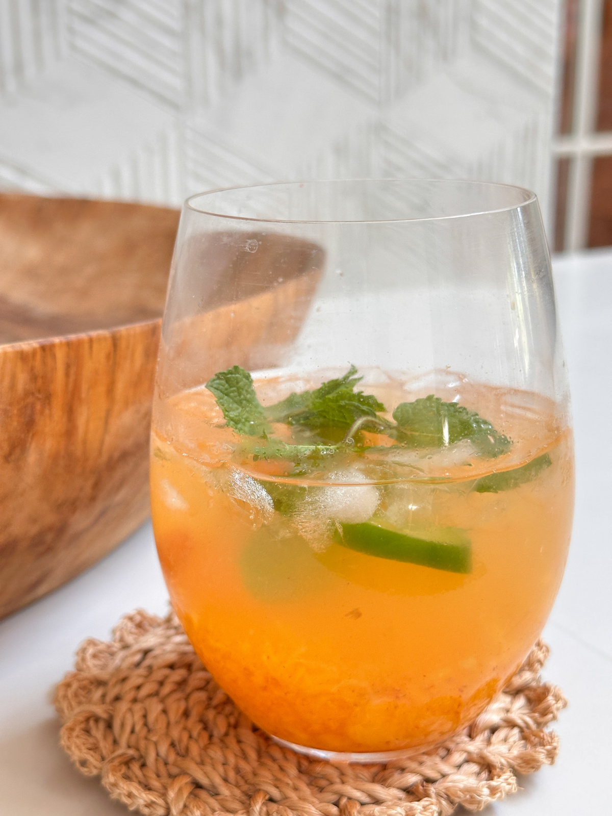 Stemless wine glass full of a peach jalapeño spritz drink.