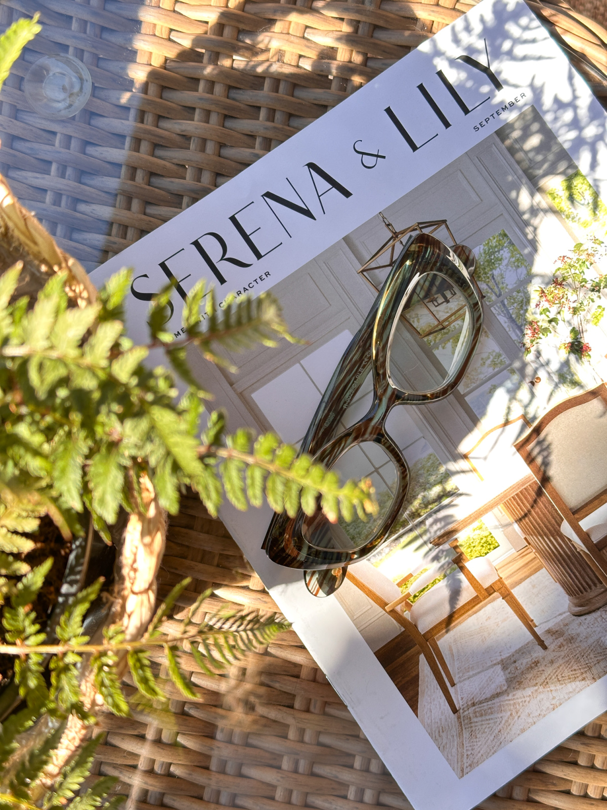 Serena & Lily catalogue on patio table with Ryan Simkhai reading glasses set on top.
