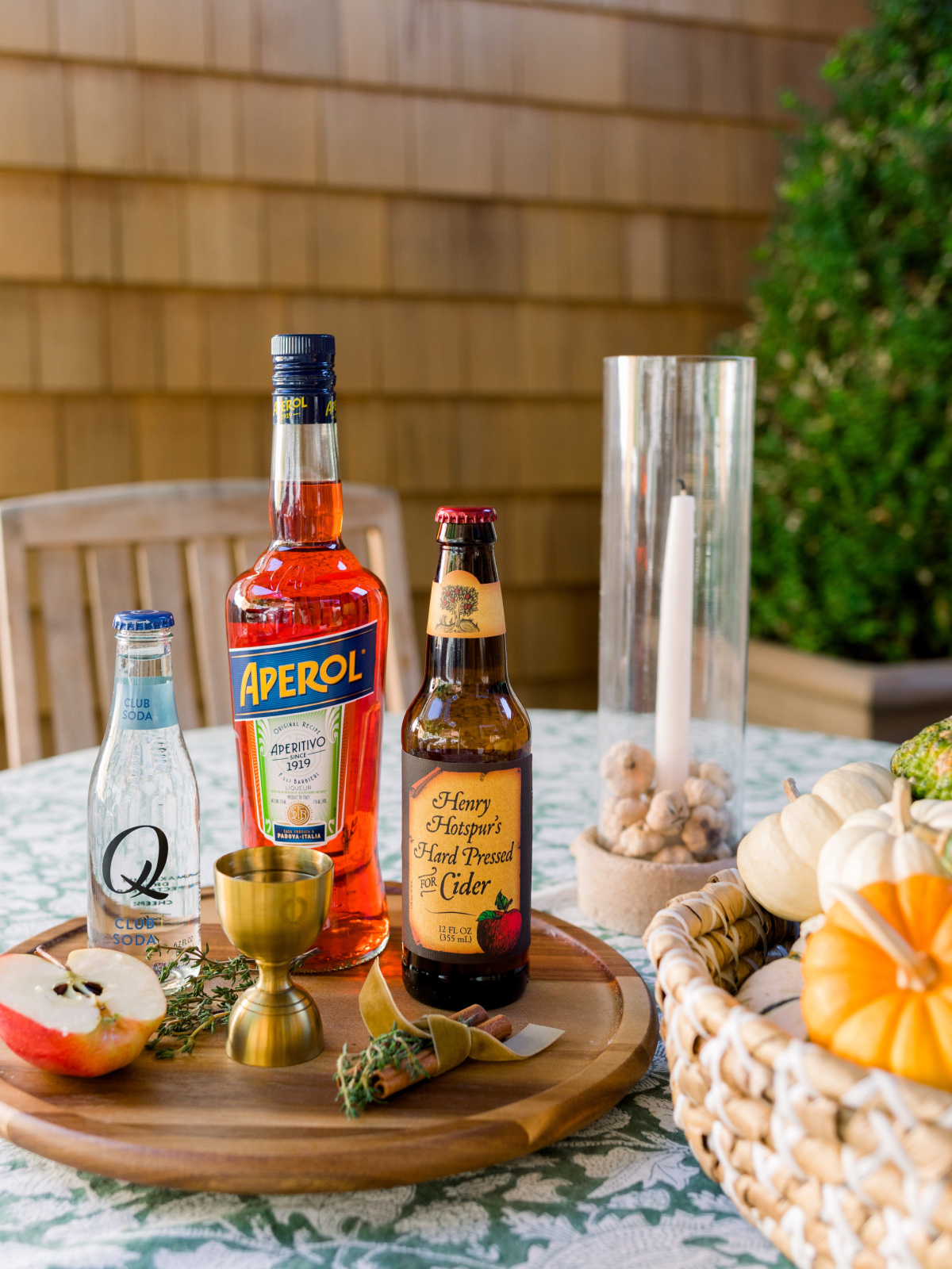 Ingredients for Apple Cider Aperol Spritz on outdoor fall table.