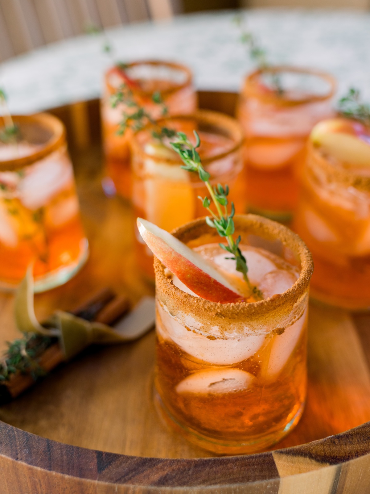 Apple Cider Aperol Spritz drinks on wooden tray.