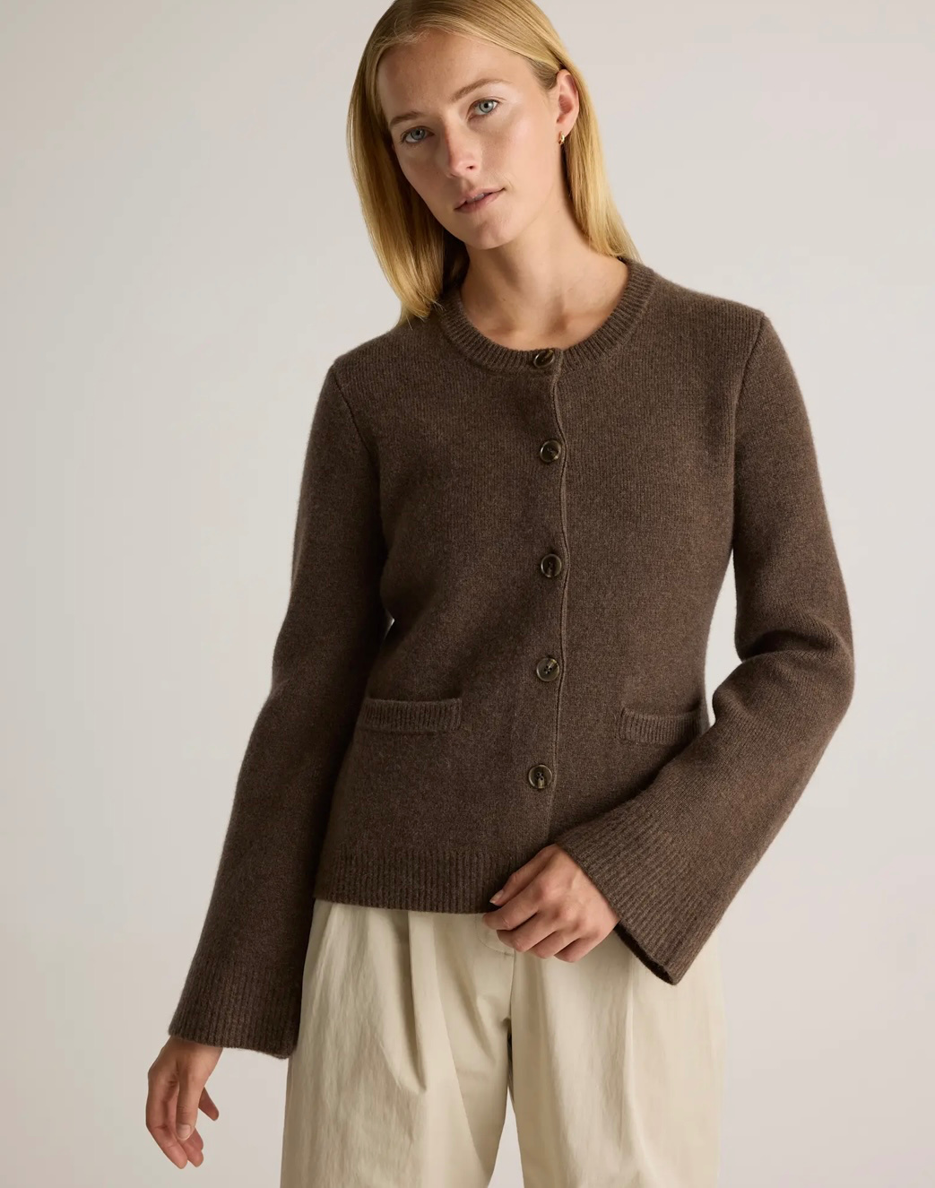 Model wearing Quince structured cardigan in chocolate brown.