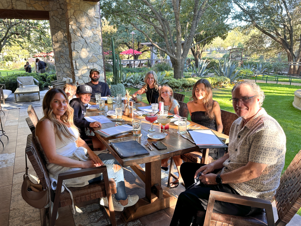 Family seated around patio table at 97 West in Ft. Worth.