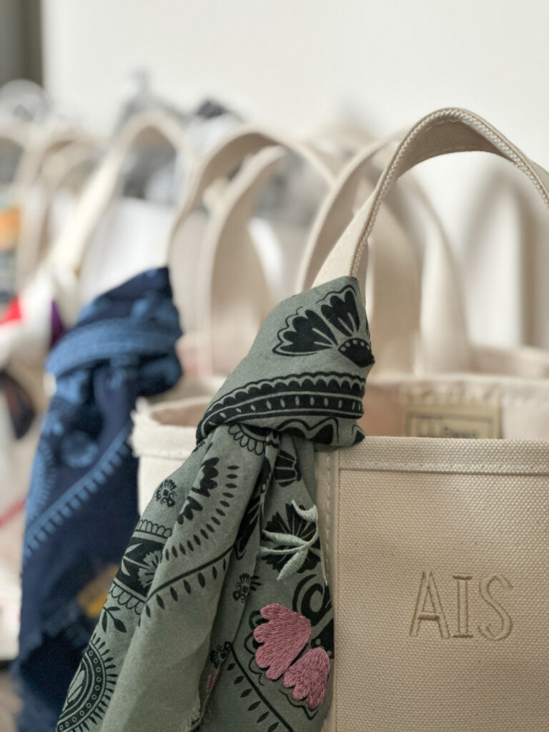 Linke of LL Bean Boat & Tote bags with scarves tied to handles.